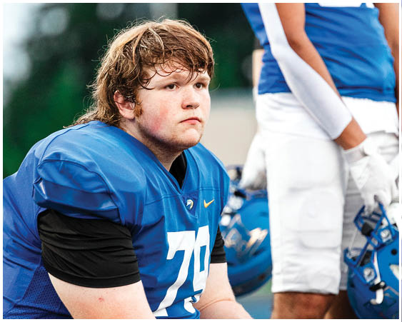 A football player wearing a blue and white uniform. Description generated by AI