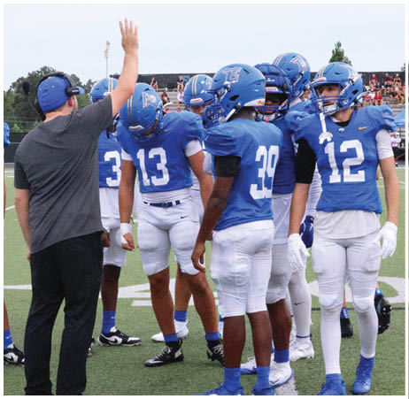 A group of football players on a field. Description generated by AI