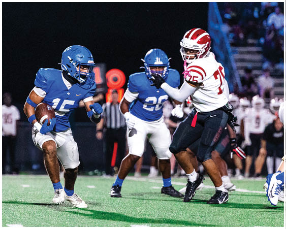 A football player wearing a blue and white uniform. Description generated by AI