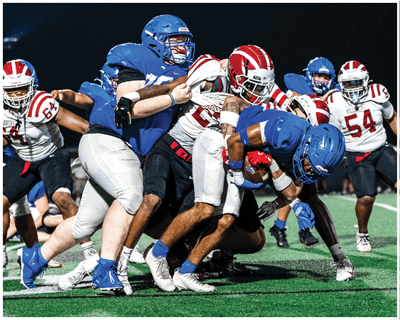 A football player wearing a blue and white uniform. Description generated by AI