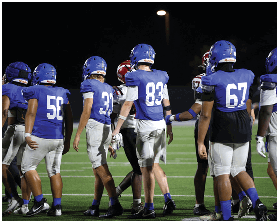 A football player wearing a blue and white uniform. Description generated by AI