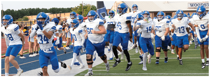A football player wearing a blue and white uniform. Description generated by AI