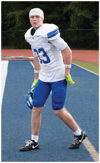 A football player catching a ball. Description generated by AI