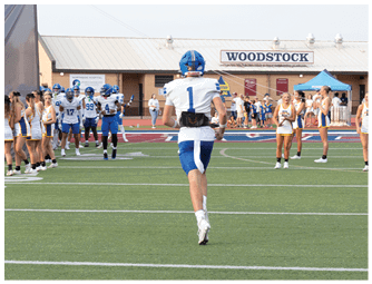 A group of football players on a field. Description generated by AI