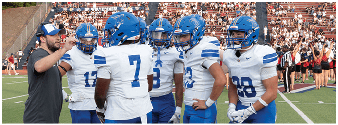 A football player wearing a blue and white uniform. Description generated by AI