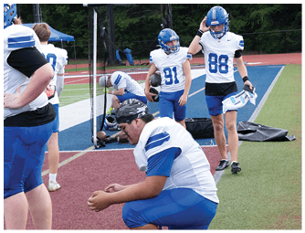 A group of football players on a field. Description generated by AI