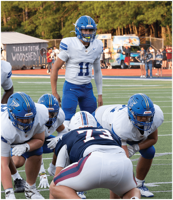 A group of football players wearing black and white uniforms. Description generated by AI