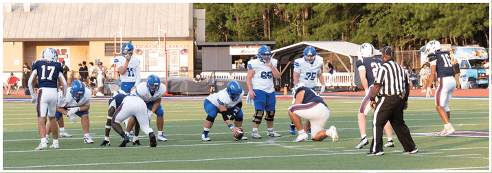 A group of football players on a field. Description generated by AI