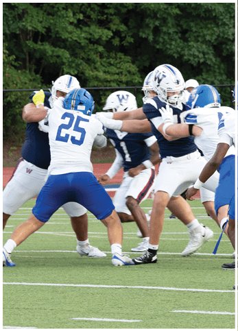 A group of football players wearing black and white uniforms. Description generated by AI