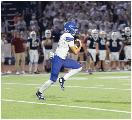 A football player running on the field. Description generated by AI