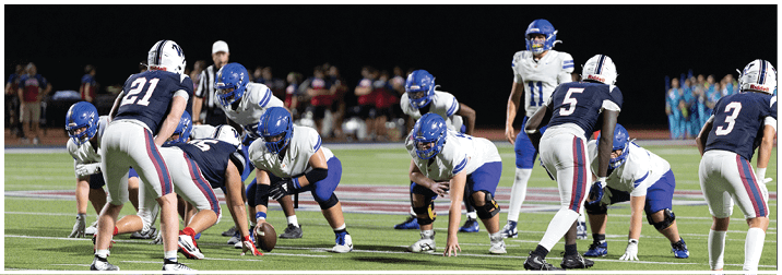 A group of football players on a field. Description generated by AI
