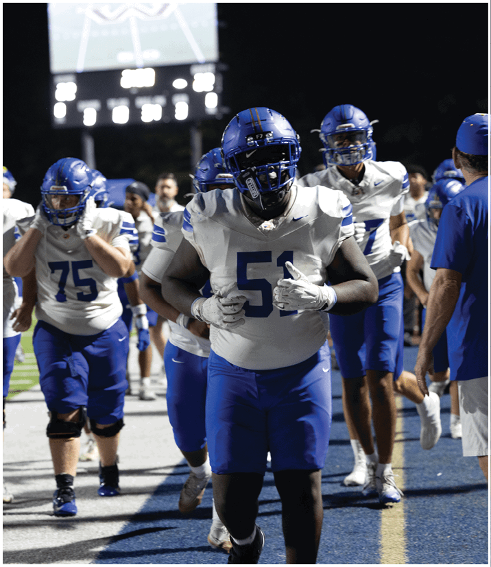 A group of football players wearing black and white uniforms. Description generated by AI