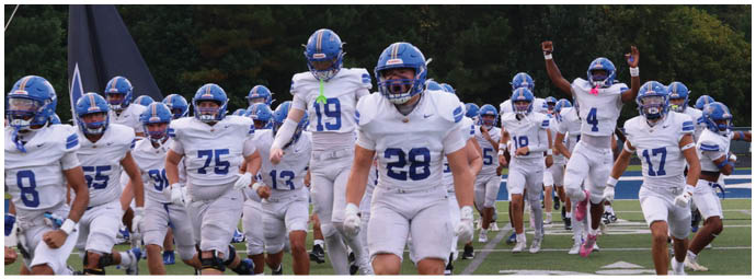 A football player wearing a blue and white uniform. Description generated by AI