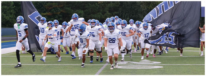 A football player wearing a blue and white uniform. Description generated by AI
