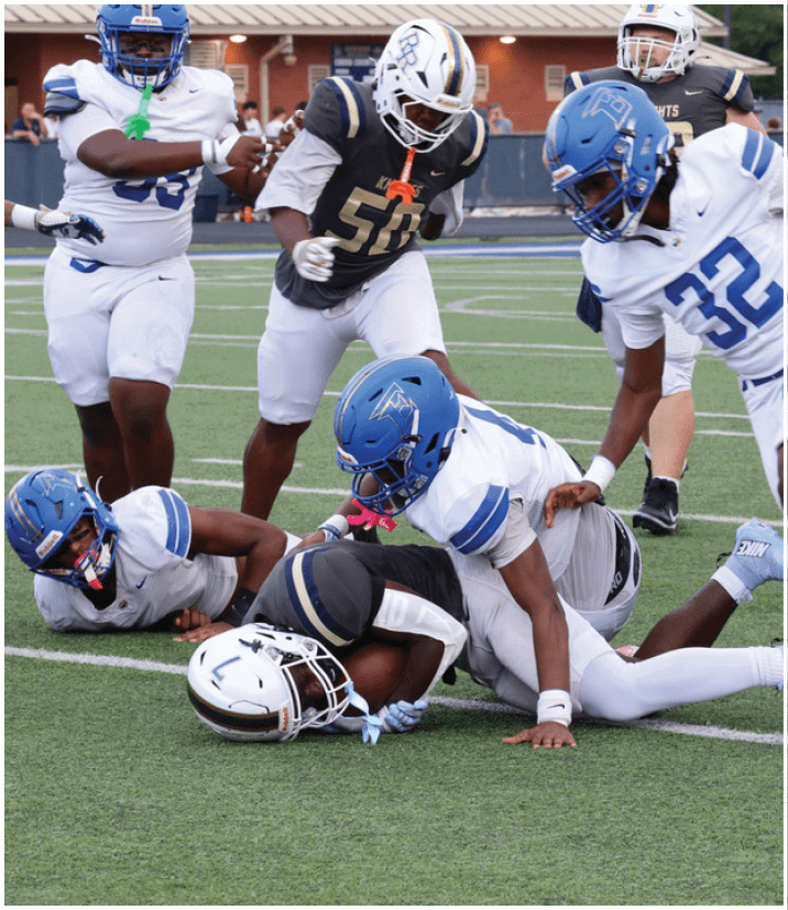 A group of football players wearing black and white uniforms. Description generated by AI