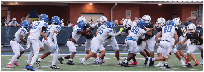 A group of football players on a field. Description generated by AI