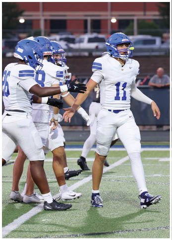 A group of football players wearing black and white uniforms. Description generated by AI