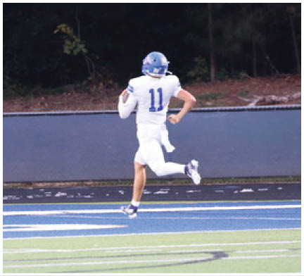 A football player running on the field. Description generated by AI