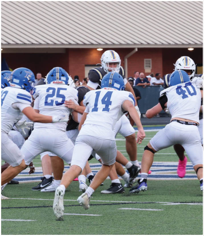 A group of football players wearing black and white uniforms. Description generated by AI