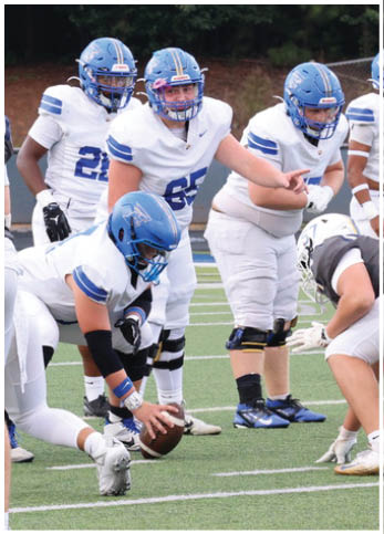 A group of football players wearing black and white uniforms. Description generated by AI