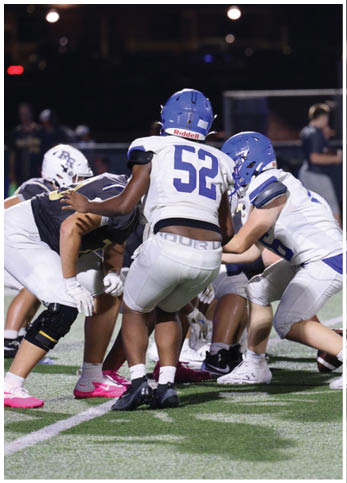 A group of football players wearing black and white uniforms. Description generated by AI