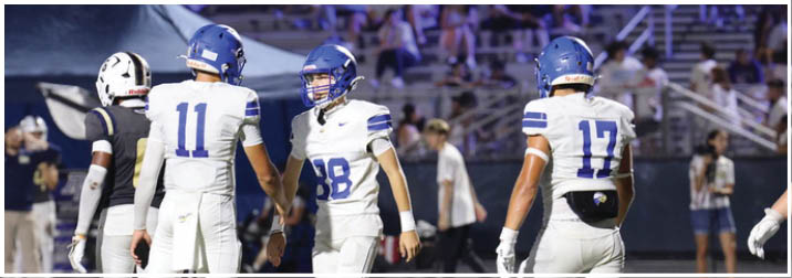 A group of football players on a field. Description generated by AI