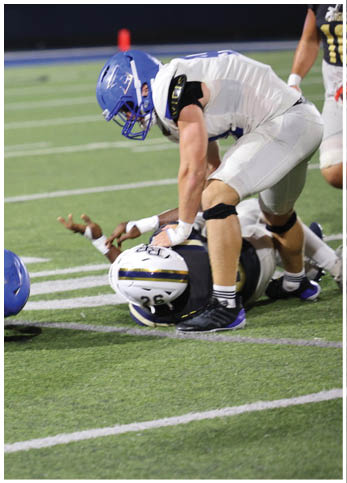 A group of football players wearing black and white uniforms. Description generated by AI
