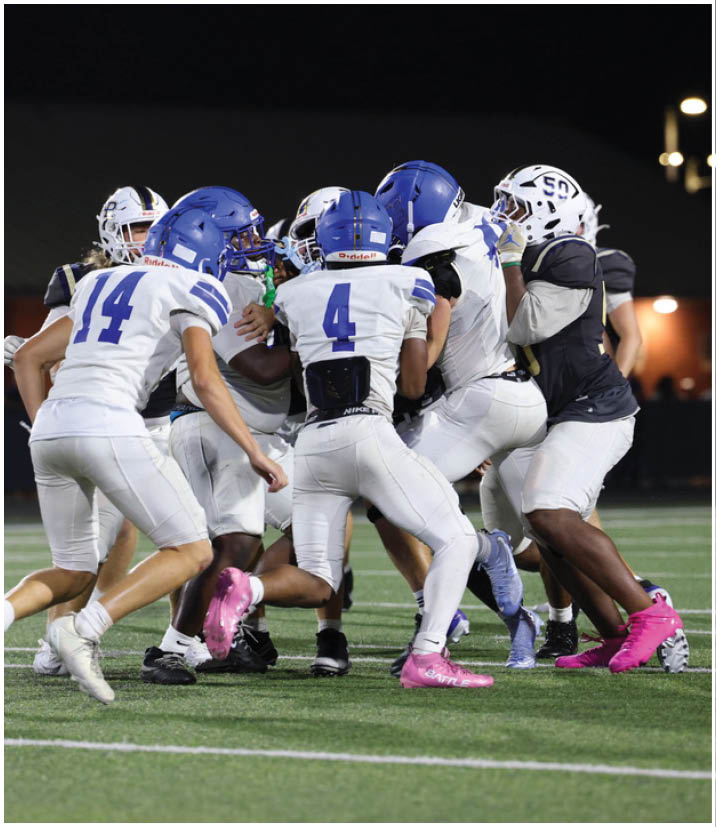 A group of football players wearing black and white uniforms. Description generated by AI