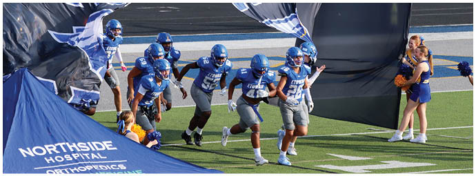 A football player wearing a blue and white uniform. Description generated by AI