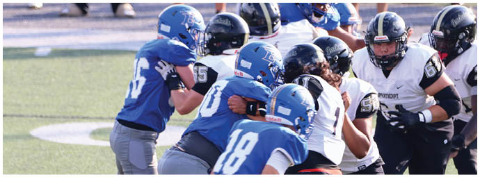 A football player wearing a blue and white uniform. Description generated by AI