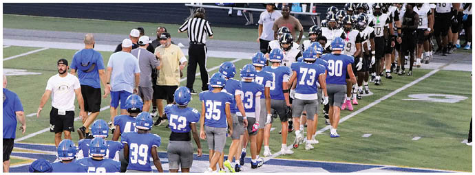 A football player wearing a blue and white uniform. Description generated by AI