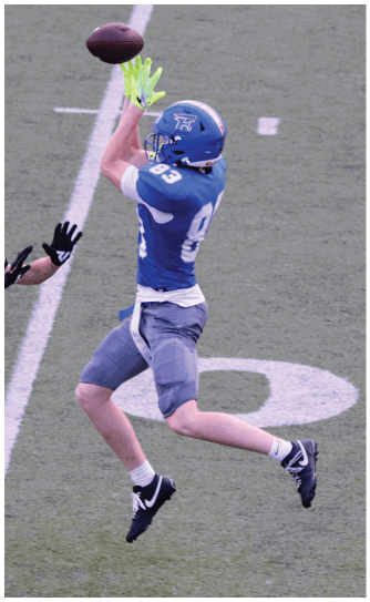 A football player catching a ball. Description generated by AI