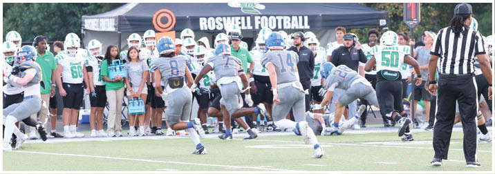 A group of football players on a field. Description generated by AI