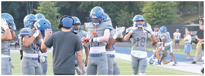 A football player wearing a blue and white uniform. Description generated by AI