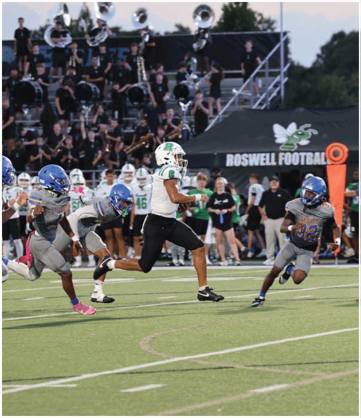 A group of football players wearing black and white uniforms. Description generated by AI