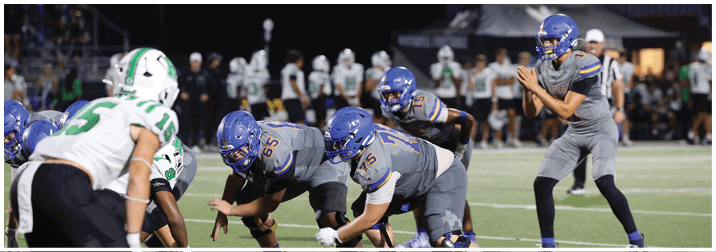 A group of football players on a field. Description generated by AI
