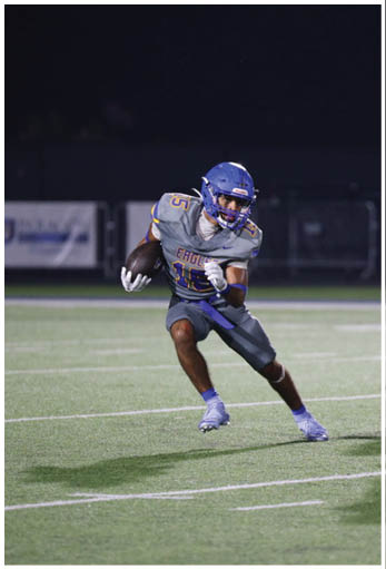 A football player running on the field. Description generated by AI