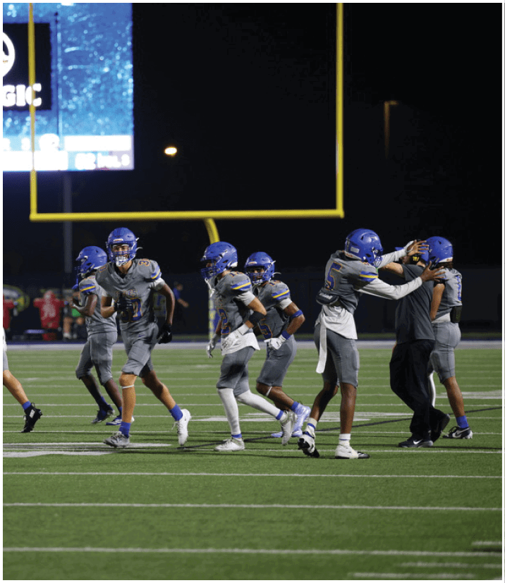 A group of football players wearing black and white uniforms. Description generated by AI