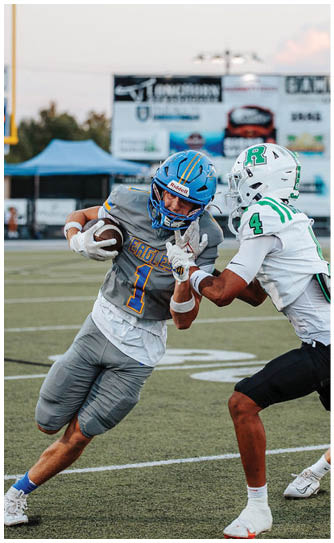 A football player catching a ball. Description generated by AI
