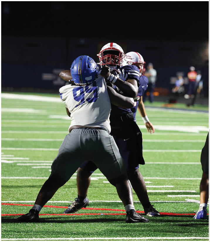 A group of football players wearing black and white uniforms. Description generated by AI