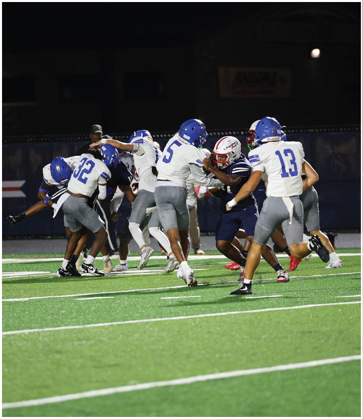 A group of football players wearing black and white uniforms. Description generated by AI