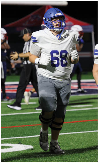 A group of football players wearing black and white uniforms. Description generated by AI