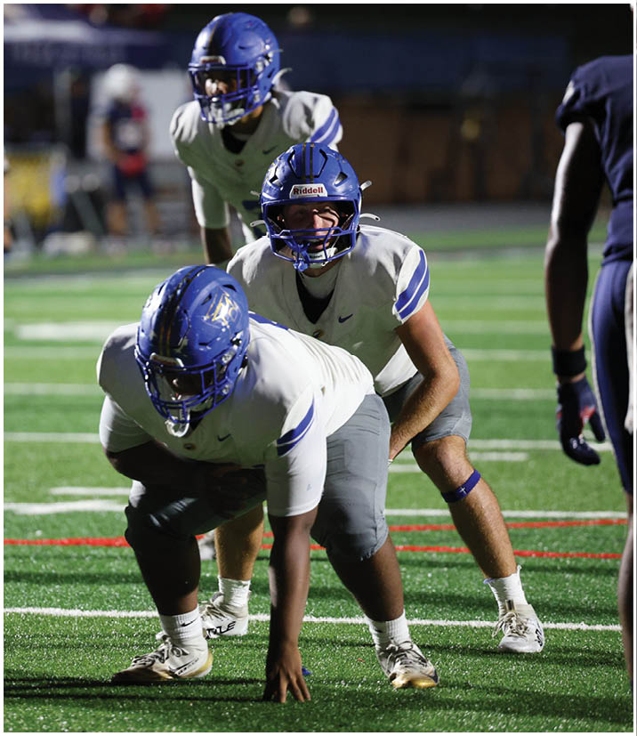 A group of football players wearing black and white uniforms. Description generated by AI