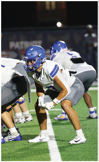 A group of football players wearing black and white uniforms. Description generated by AI
