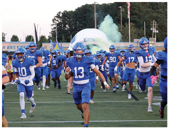 A group of football players on a field. Description generated by AI
