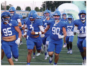 A group of football players on a field. Description generated by AI