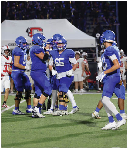 A group of football players wearing black and white uniforms. Description generated by AI