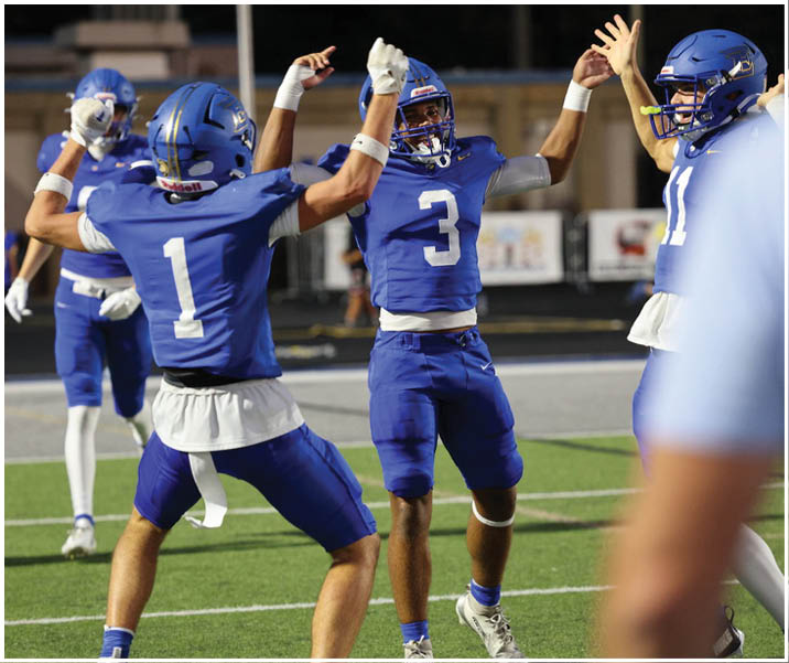 A group of football players wearing black and white uniforms. Description generated by AI