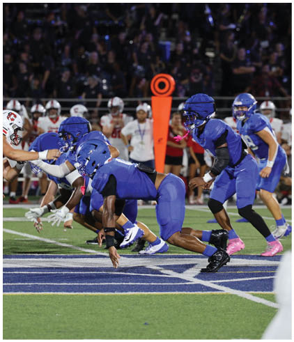 A group of football players wearing black and white uniforms. Description generated by AI