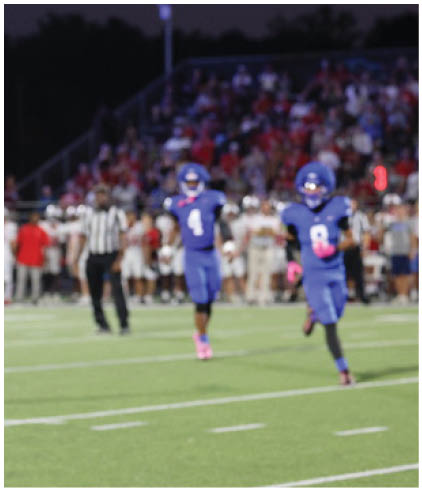 A group of football players wearing black and white uniforms. Description generated by AI